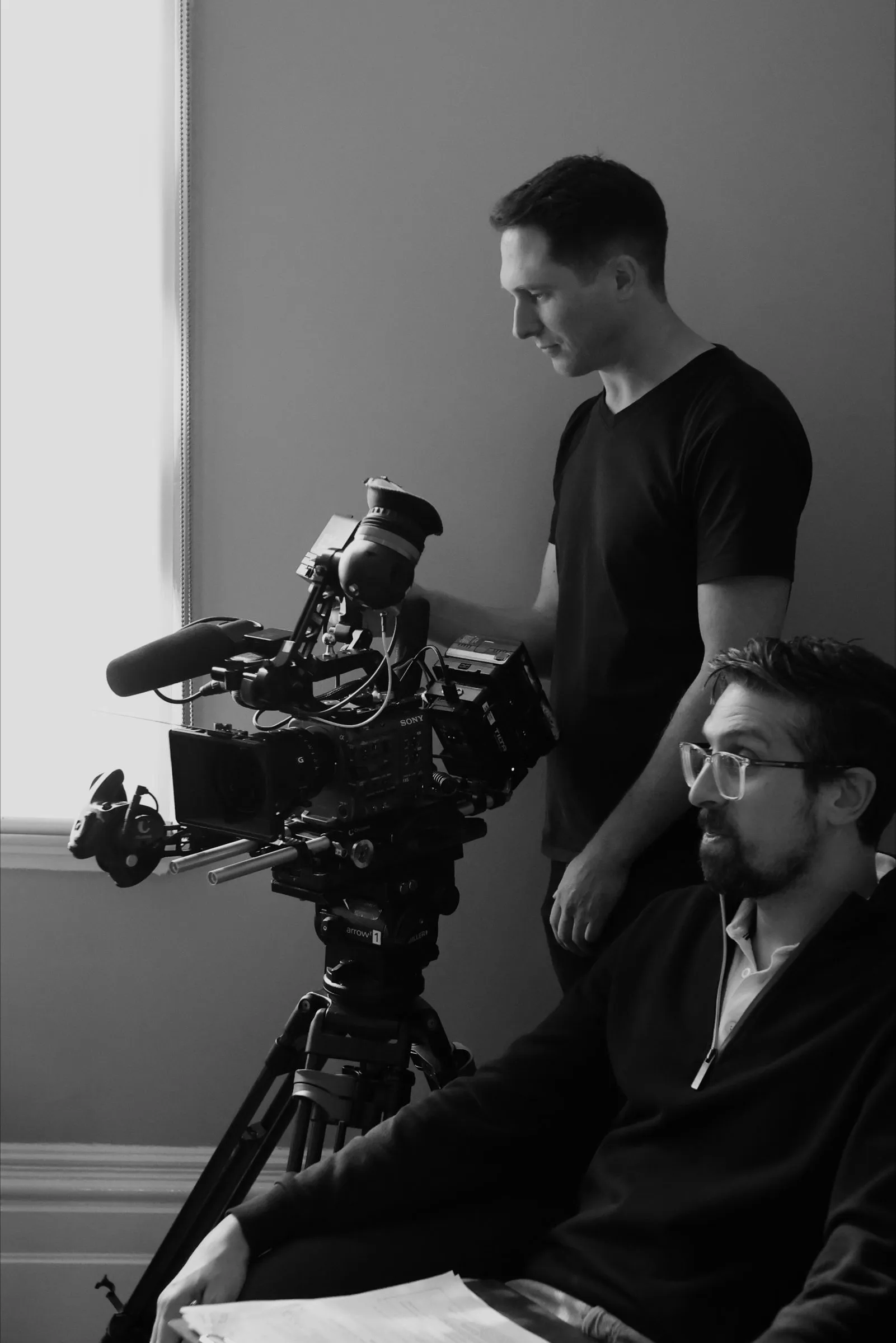 Matthew operating a camera on a tripod during an interview shoot